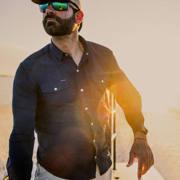 man driving boat with navy pearl snap shirt