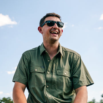 man smiling in green short sleeve shirt