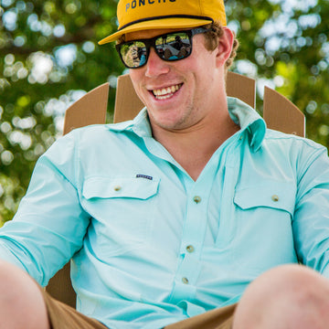 man smiling wearing light green shirt