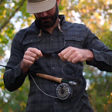 man going fishing in black plaid flannel