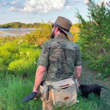 man with dog wearing camo shirt