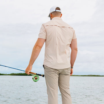 man wearing short sleeve orange shirt with fishing rod