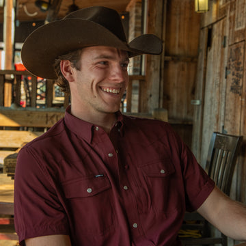 man smiling in short sleeve maroon shirt