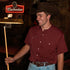 man holding pool cue in maroon short sleeve shirt