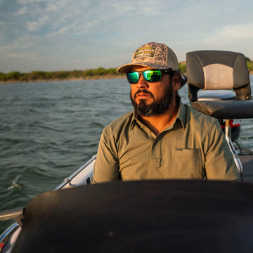 man on boat wearing green polo shirt