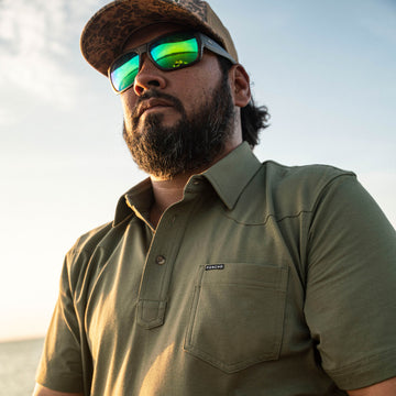 man with sunglasses wearing green polo shirt