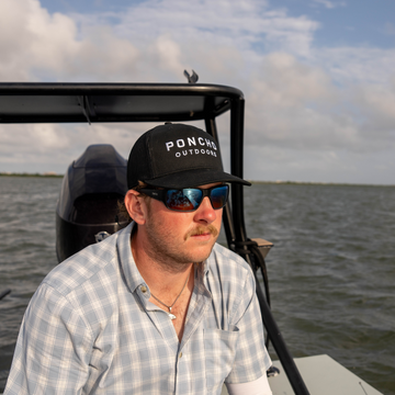 Man looking out at the water while wearing The Man In Black Hat