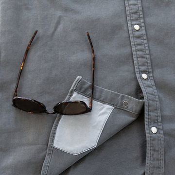 sunglasses with lens cleaner on shirt