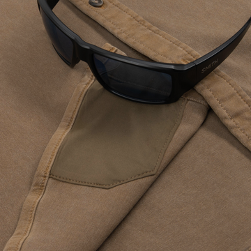 Close-up of The Monteagle black sunglasses resting on tan shirt fabric with stitched pocket detail