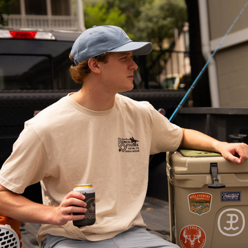 man wearing open range tee holding drink