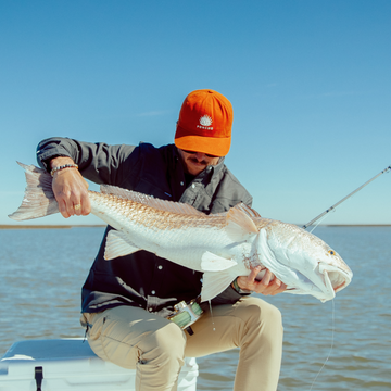 man with fish in orange agave hat