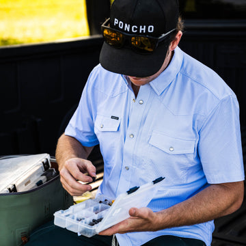 The Padre light blue short sleeve shirt worn outdoors while organizing a tackle box