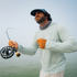 man casting fishing rod with sea grass hoodie