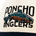 Close-up of a beige and navy cap with embroidered colorful fish and the text "Poncho Anglers" on the front.