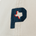 Close-up of a beige fabric with a navy blue embroidered letter P featuring a small red and white Texas state outline inside.