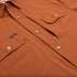 close up of buttons and pockets on burnt orange shirt