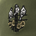 Embroidered design of three birds perched on a post with yellow flowers on an olive green fabric background