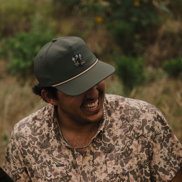 The Popper Hat worn by a smiling man outdoors in a patterned button-up shirt