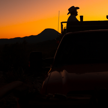 Men sitting in truck at sunset