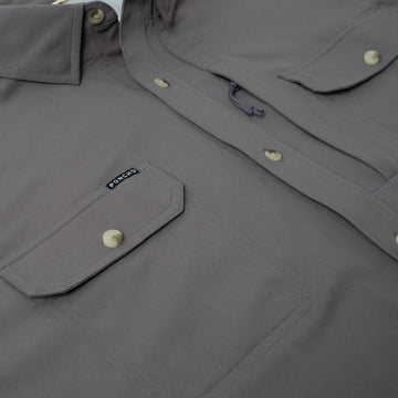 Close up of chest pocket on grey button down fishing shirt