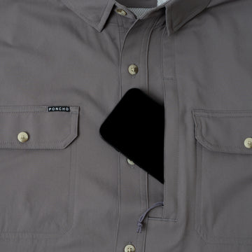 phone in chest pocket of grey button down fishing shirt