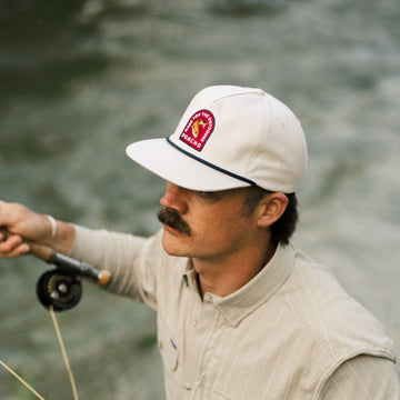 man holding fishing rod wearing redfish rope hat