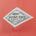 Close-up of a diamond-shaped white fabric patch on coral fabric with "PONCHO" and a fish graphic stitched, promoting outdoor fishing shirts.