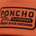 Close-up of orange fabric with a black embroidered Poncho Outdoors patch reading Chasin Dutch Chickens
