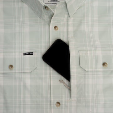 Phone in chest pocket of green plaid button down shirt