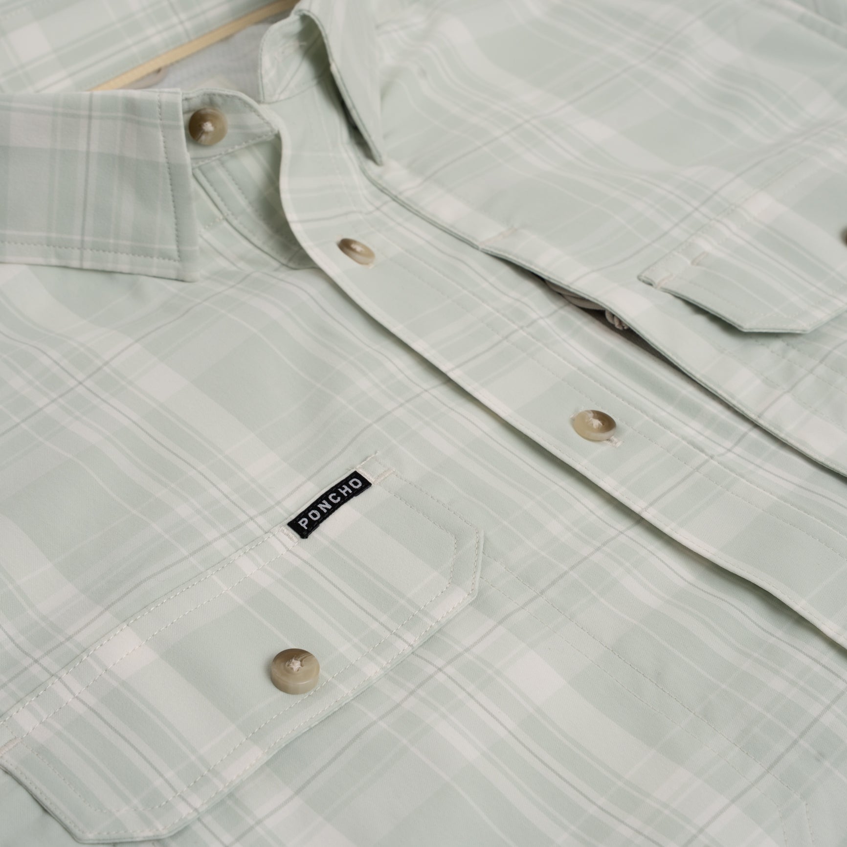 Close up of green plaid button down