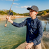 boy casting fishing pole at lake wearing blue button down fishing pole