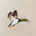 Close-up of detailed embroidery depicting a flying mallard duck on beige fabric.