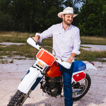 man wearing the 150 shirt on a dirtbike