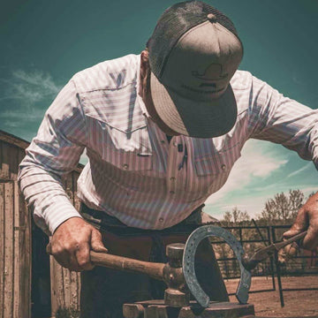 man wearing the 1776 making a horseshoe