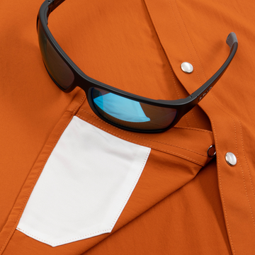 Closeup of sunglasses with lens cleaner on shirt