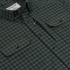 Close-up of The Acadia green plaid shirt with buttoned chest pockets and Poncho Outdoors label detail.
