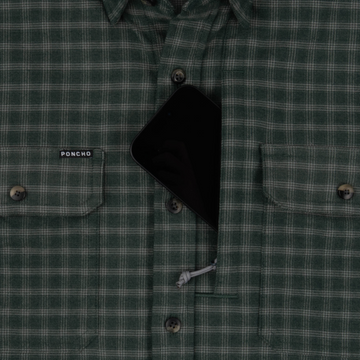 Close-up of The Acadia shirt in green plaid fabric featuring button closures and a pocket holding a black smartphone.