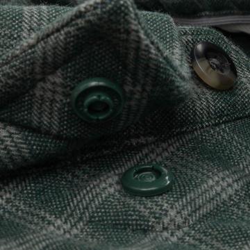 Close-up of green textured fabric with buttons on The Acadia shirt highlighting its sturdy stitching and outdoor style.