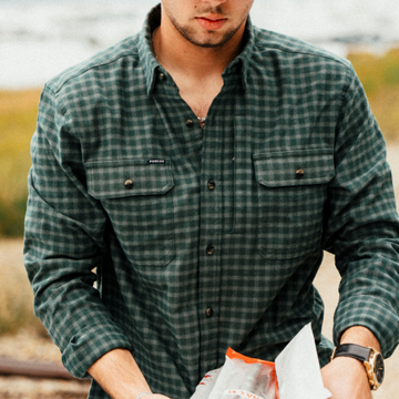 The Acadia teal and white plaid men's outdoor shirt with long sleeves and buttoned chest pockets outdoors