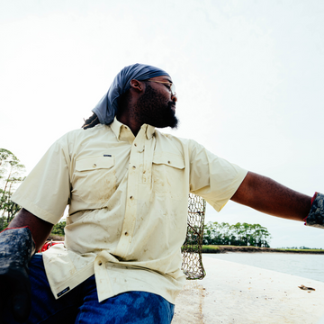 man on the water wearing tan long sleeve shirt