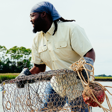 man holding cage wearing tan short sleeve shirt