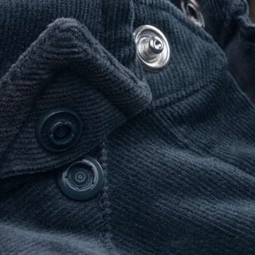 Close-up of textured fabric with buttons and snaps on The Barton Springs shirt, highlighting its detailed design.