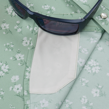 Close-up of a floral patterned shirt pocket from The Bat Masterson with dark sunglasses resting on it.