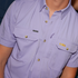 Close-up of a lavender short-sleeve shirt "The Baton Rouge" with buttoned chest pockets and LSU embroidery.
