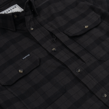 Close-up of The Black Canyon shirt in dark checkered pattern with buttoned chest pockets and collar detail.