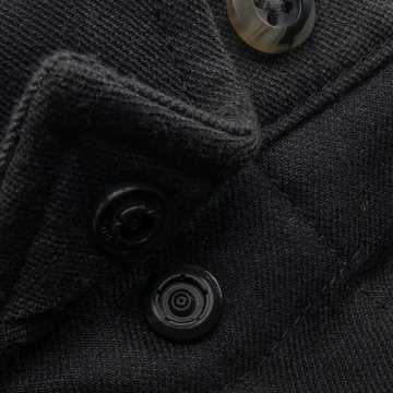 Close-up of black fabric and buttons on The Black Canyon shirt showcasing texture and stitch details.