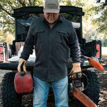 The Blacksburg dark button up shirt worn outdoors beside a utility vehicle