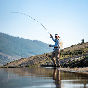 The Buckhorn shirt worn by an angler fly fishing beside a mountain lake