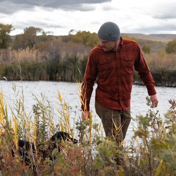 Man walking with dog wearing he buena vista flannel shirt