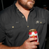 Close-up of a man wearing The Buff black outdoor shirt holding a beer can